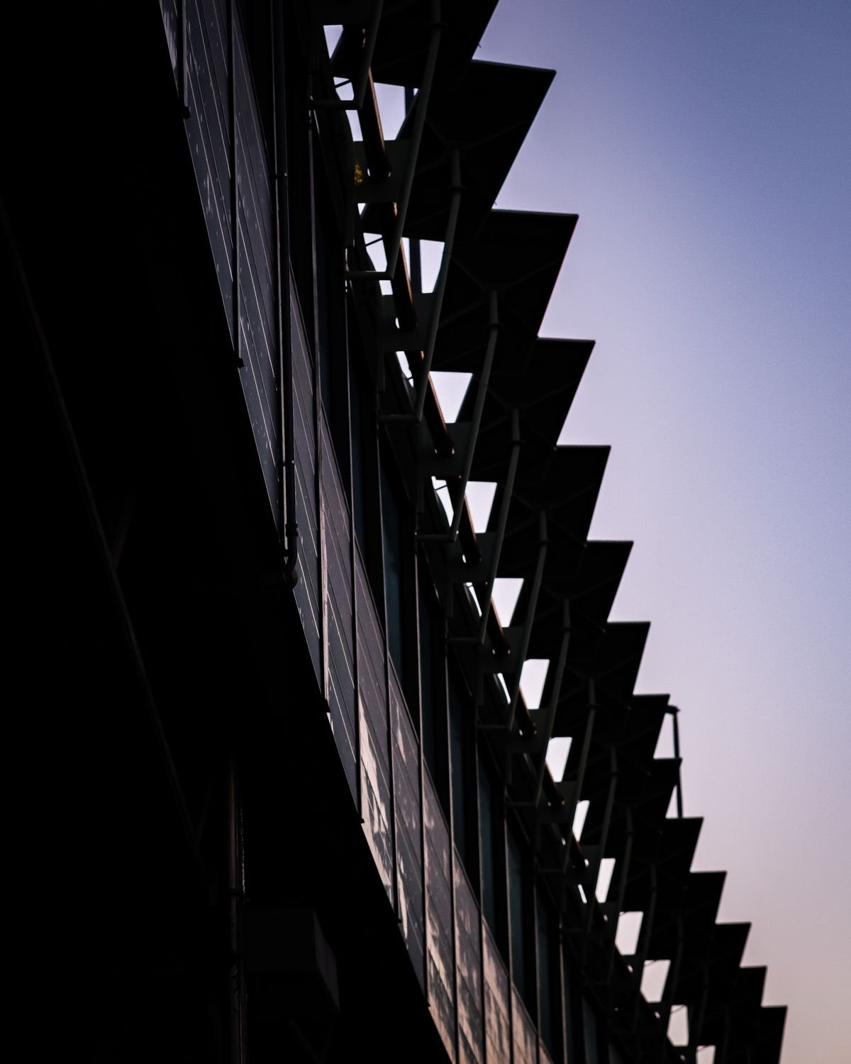Dark louvred facade silhouetted against a dusk sky
